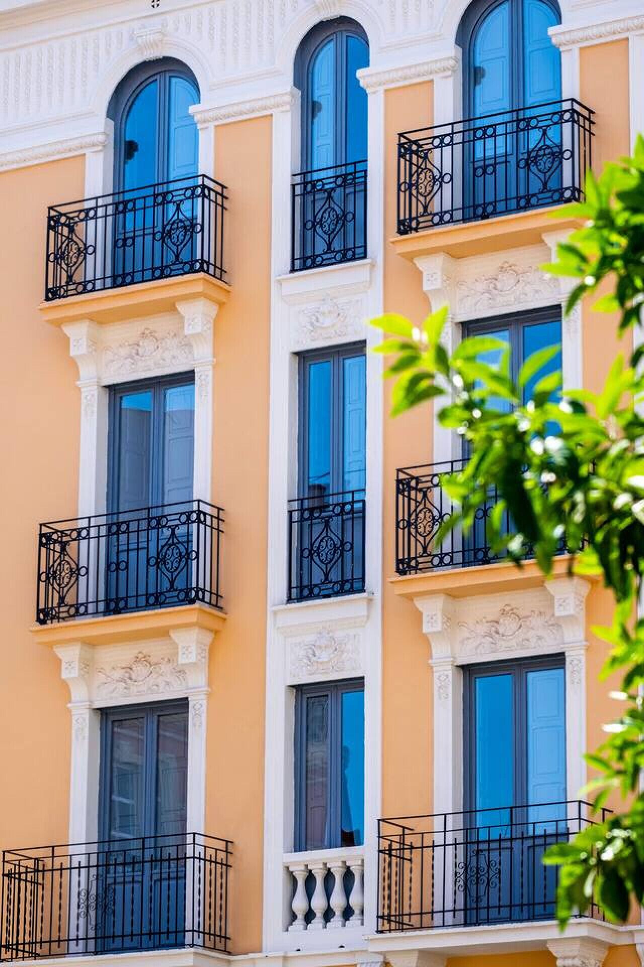 A multi-story building with balconies and large windows.