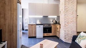 Eine moderne Küche mit Holzausstattung, einem Geschirrspüler und einer Wand mit Backsteinverkleidung.