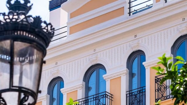 Um edifício com várias varandas, janelas amplas e um poste de luz em primeiro plano.