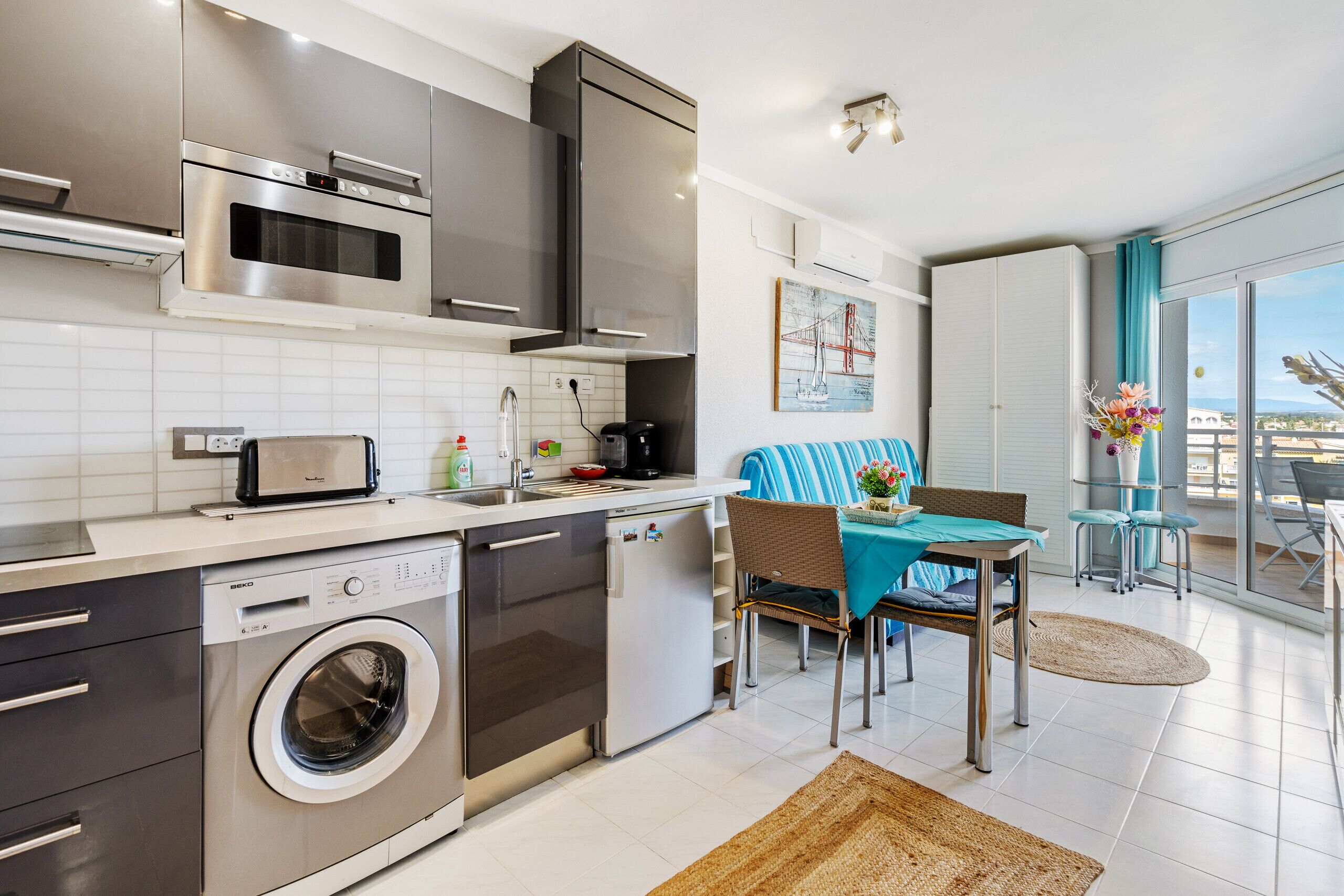 A modern kitchen with stainless steel appliances, a dishwasher, and a built-in washing machine.