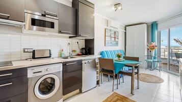 A modern kitchen with stainless steel appliances, a dishwasher, and a built-in washing machine.