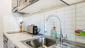 Een moderne keuken met een roestvrijstalen spoelbak, een broodrooster en een fles afwasmiddel.