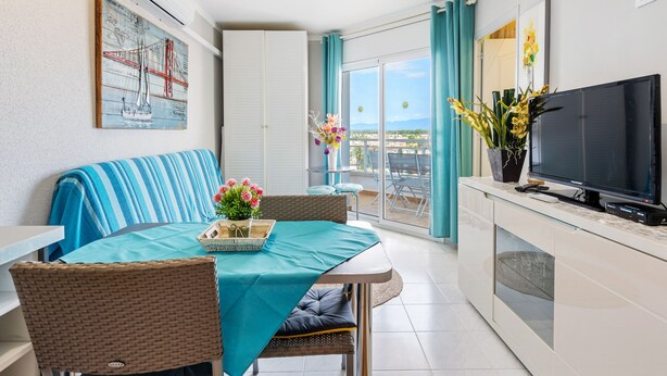 Een moderne woonkamer met een eethoek, een televisie en een balkon met uitzicht.