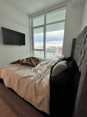 Enjoy a city view from the large window, with a comfortable bed and a flat-screen TV.