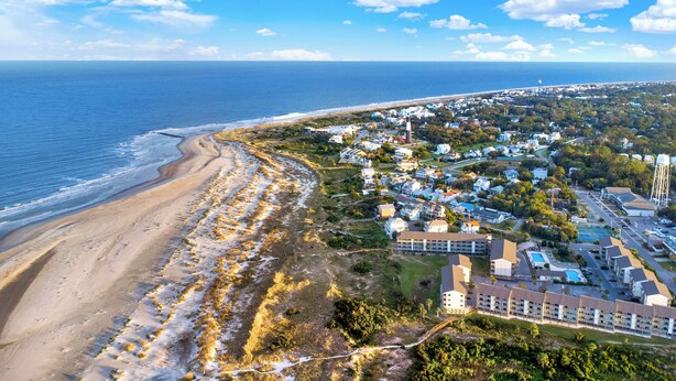 A coastal town with beachfront properties, a large hotel, and a water tower.