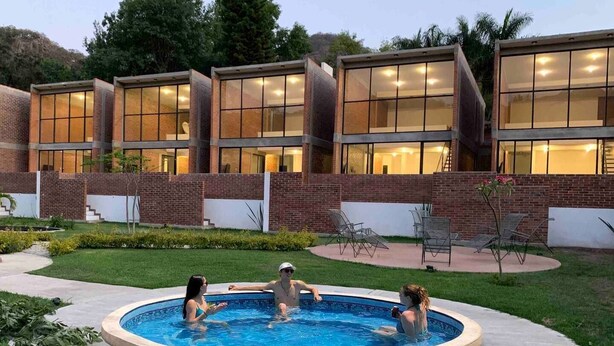 Un bâtiment moderne doté de grandes fenêtres en verre et d’un espace piscine.