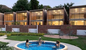 Un edificio moderno con amplios ventanales y zona de piscina.