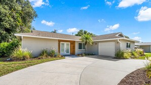 Une maison de plain-pied avec un garage, une porte d’entrée et une allée.