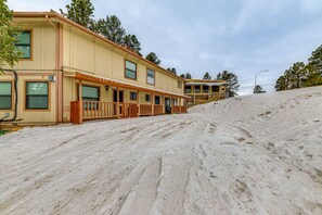A two-story building with a covered porch and a sandy slope. - Ruidoso Home w/ Balcony ~ 16 Mi to Ski Apache! (Ruidoso)
