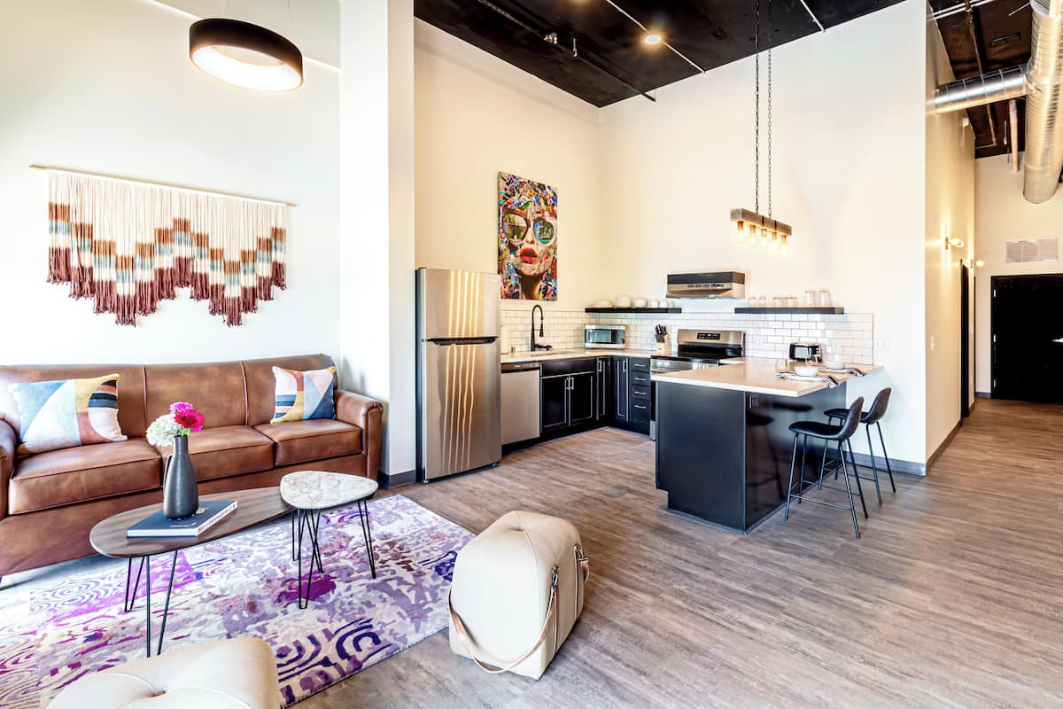 A modern living room with a brown sofa, a coffee table, and a rug.