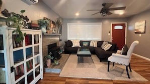A living room with a fireplace, a sofa set, a coffee table, and a bookshelf. - Dream Catcher Getaway (Clearlake Oaks)