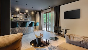 A modern living room with a bar area, seating, and a large window with a view. - VILA NICOL TIRELI premium and private Villa in Istria for your family vacation (Boljevići)