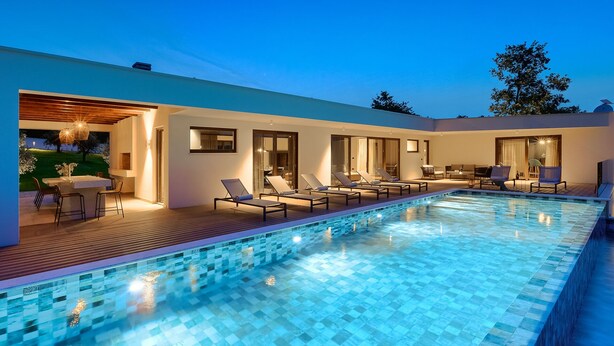 A modern outdoor pool area with lounge chairs and a dining area. - VILA NICOL TIRELI premium and private Villa in Istria for your family vacation (Boljevići)