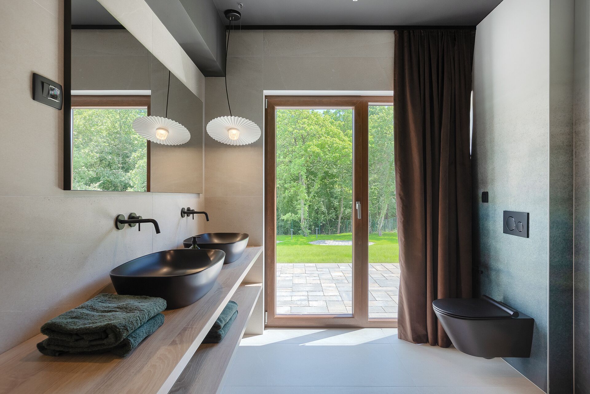 Une salle de bain moderne avec une grande fenêtre, deux lavabos et des toilettes.