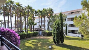 A hotel courtyard with palm trees, a white building, and a small gazebo. - Vacances EN Corse (San-Nicolao)