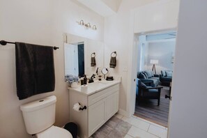Une salle de bain équipée de toilettes, d’un lavabo et d’un porte-serviettes.