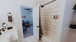 Een badkamer met douche, toilet en wastafel.