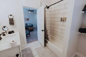 A bathroom with a shower, toilet, and sink.