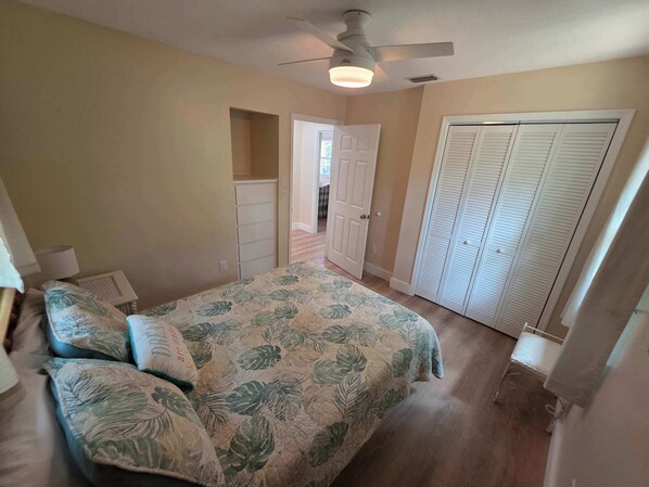 A bedroom with a bed, a dresser, a closet, and a ceiling fan. - Life at the lake Summ (Inverness)