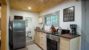 Una cocina moderna con electrodomésticos de acero inoxidable, armarios de madera y un ventanal que proporciona luz natural.