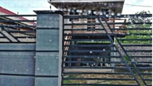 A gated building with a staircase leading to a second floor. - Cabaña Silva (Tocoa)