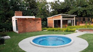 Une maison moderne dotée d’une piscine, entourée d’une pelouse bien entretenue et d’arbres.