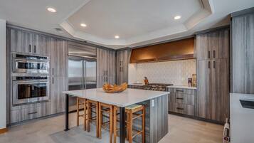 Una cocina moderna con electrodomésticos integrados, una isla central y armarios de madera.