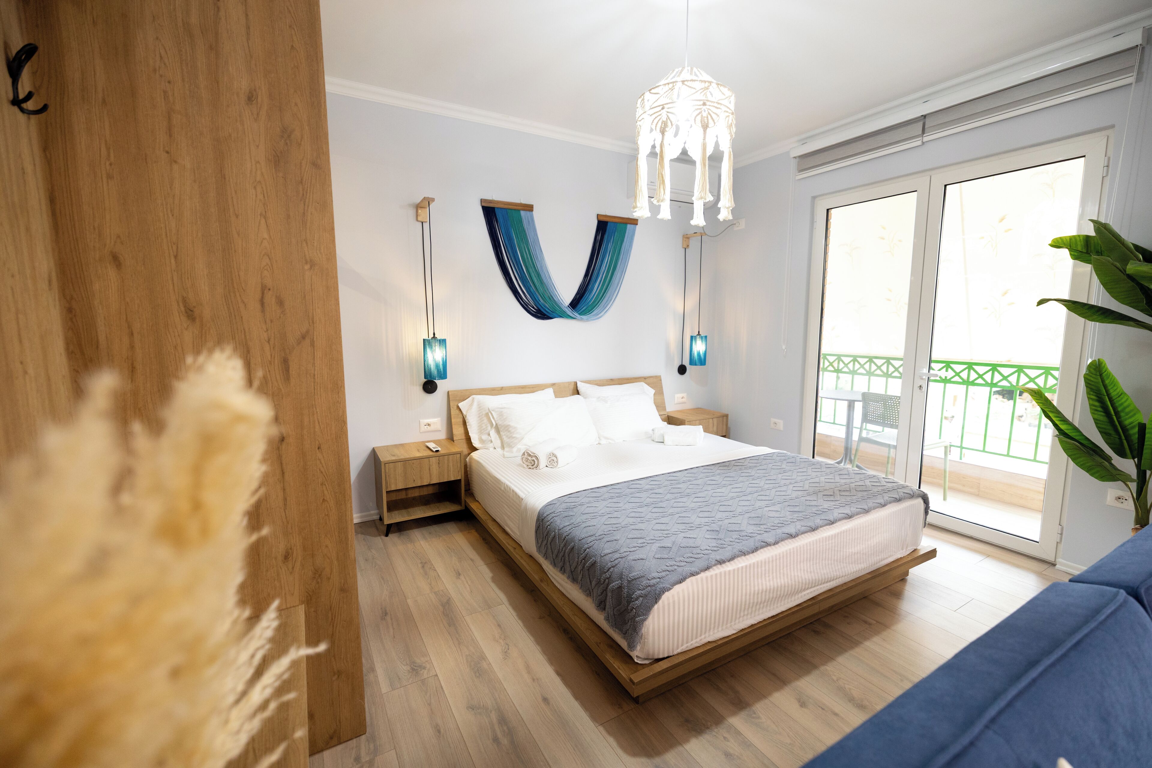 Un dormitorio moderno con una cama de madera, un ventanal grande y un balcón.