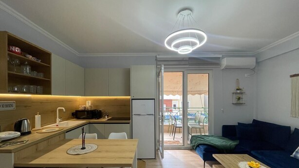 A compact apartment with a kitchenette, dining area, and a living room with a sofa and a table. -  Boho Central Apartment (Tirana)