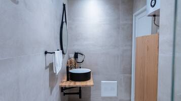 Deluxe kamer (2) | Badkamer | Een regendouche, een haardroger, badjassen, pantoffels