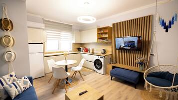 Un espacio habitable compacto con cocina, comedor y zona de estar.