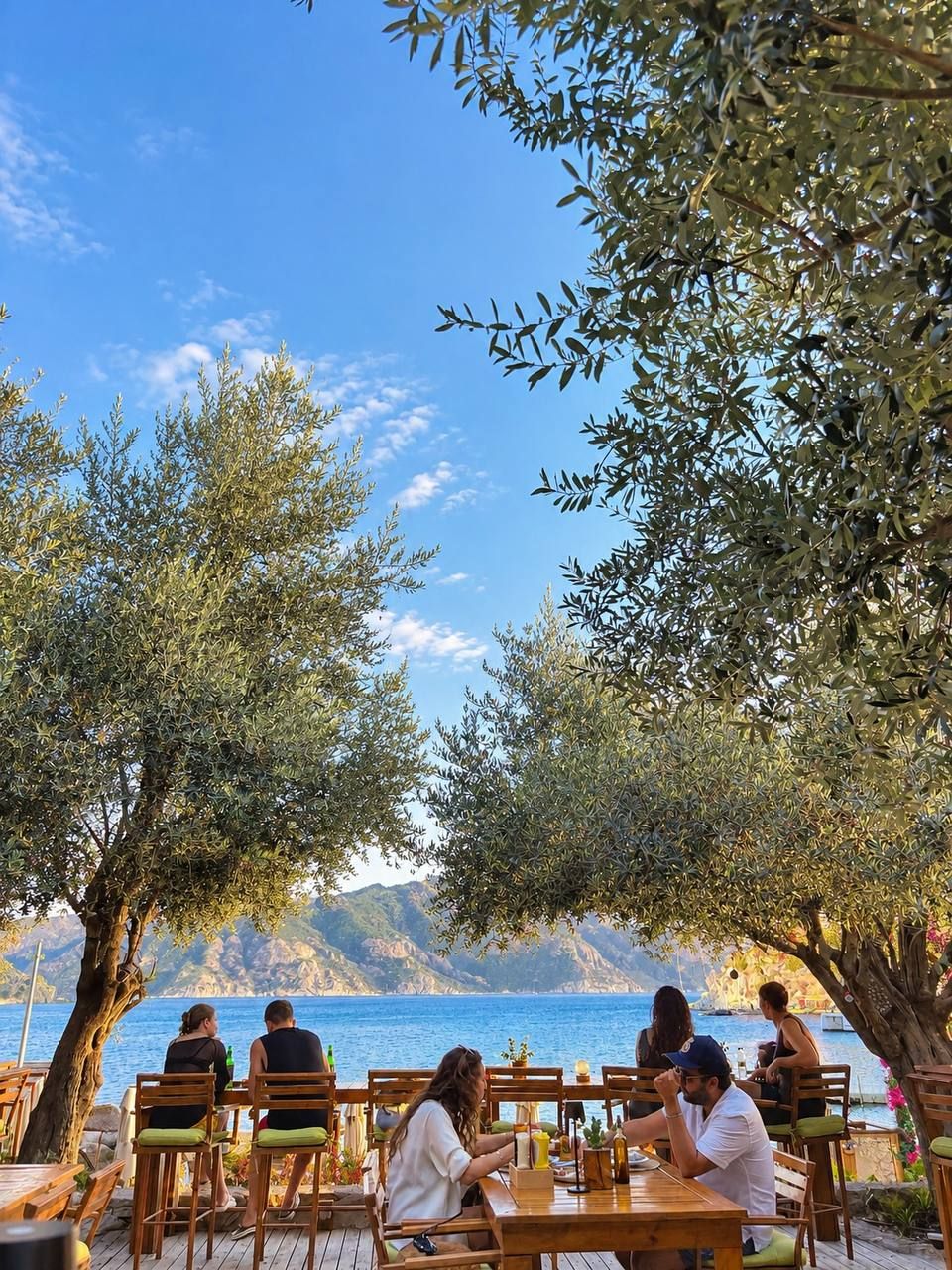 A seaside restaurant with outdoor seating, overlooking the sea.