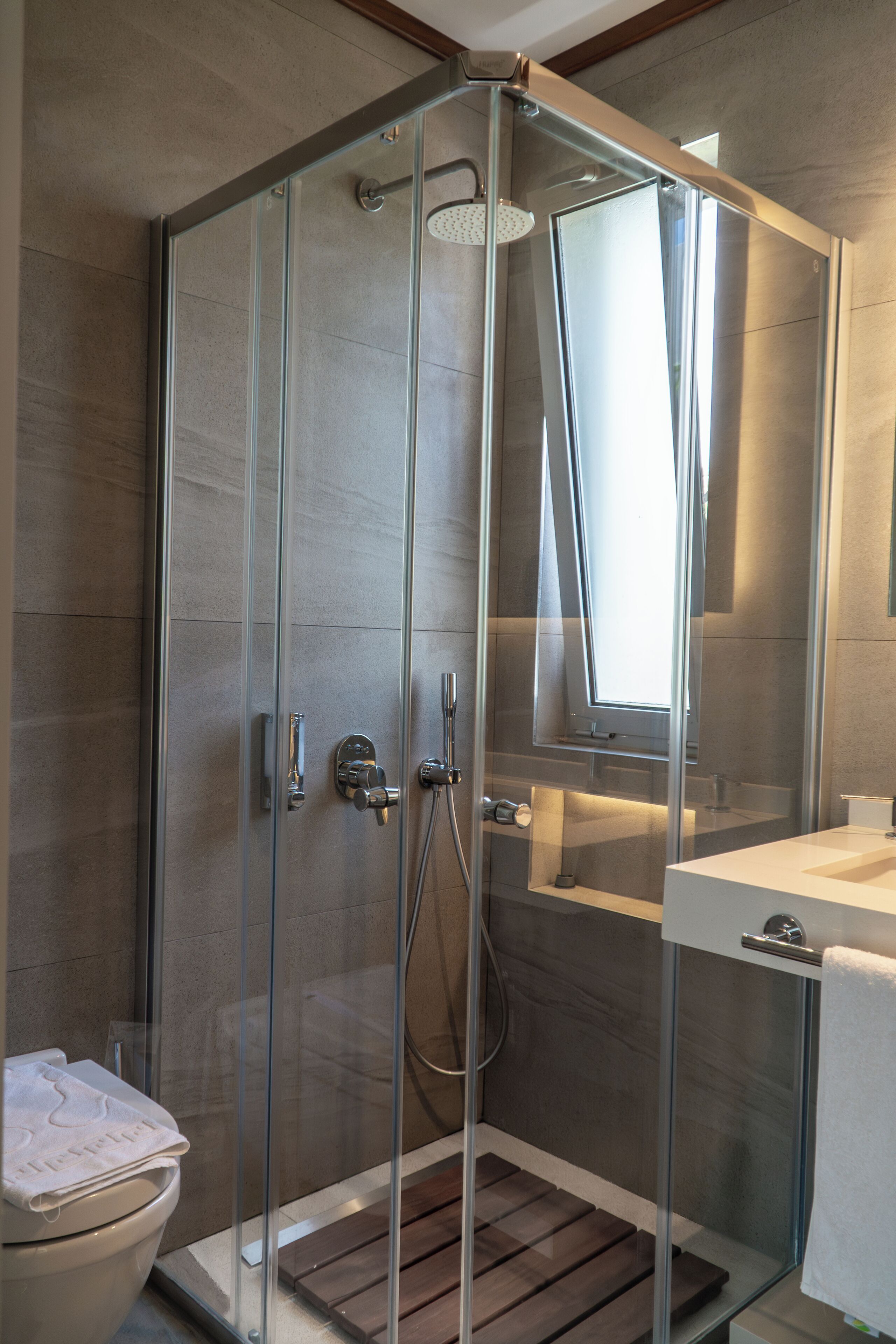 Une salle de bain moderne avec une douche à parois de verre, des toilettes et un lavabo avec un miroir.