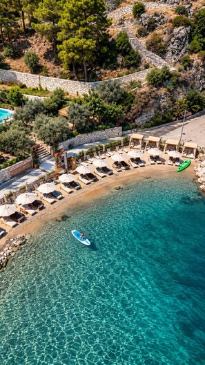 A coastal resort with a clear turquoise sea, a stone pathway, and sun loungers. - Z-Villas (Marmaris)