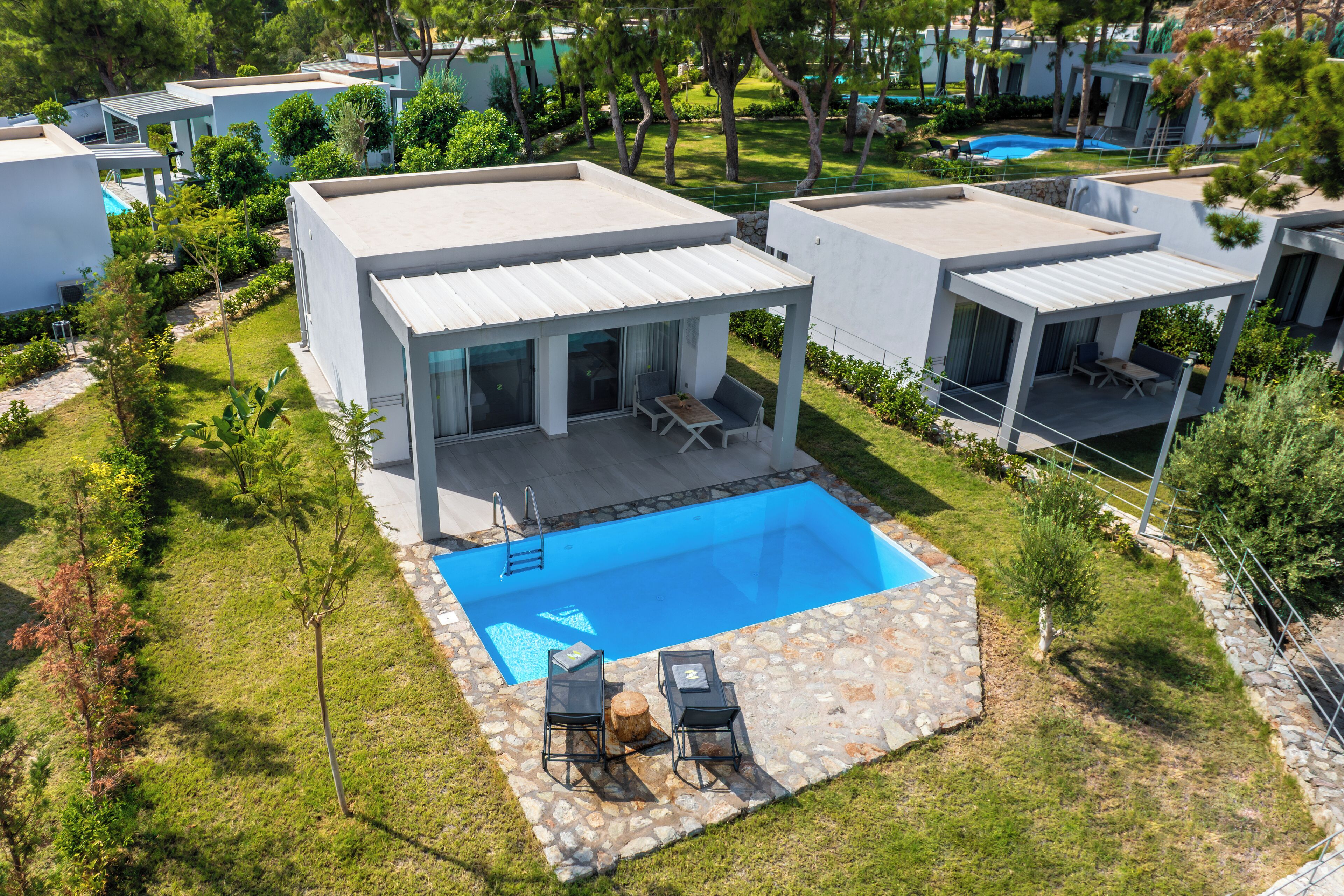 Eine moderne Villa mit Swimmingpool, Außenbereich und einer Steinterrasse.