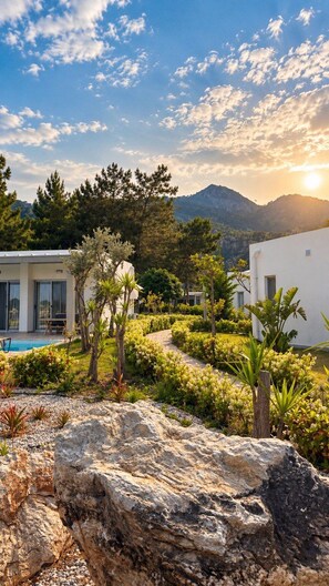 A modern outdoor area with a pool, white buildings, and a mountainous backdrop. - Z-Villas (Marmaris)