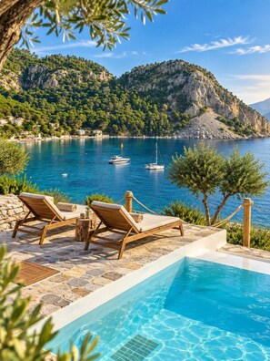 A poolside area with lounge chairs and a view of a lake with boats. - Z-Villas (Marmaris)
