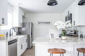 Enjoy cooking in this well-equipped kitchen with a central island, stainless steel appliances, and a convenient coffee maker.