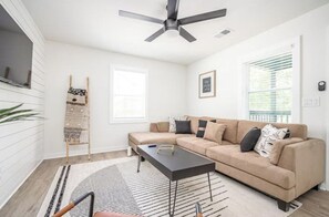 Relax in this inviting living space with a comfortable sofa, coffee table, and large window.