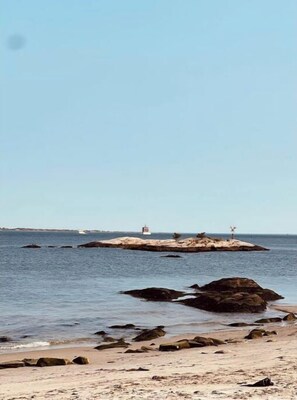 A coastal scene with a rocky outcrop, a lighthouse, and calm sea. - Waterford, CT - Beautifully furnished 1Bedroom/1Bath 864sf Apartment (Waterford)