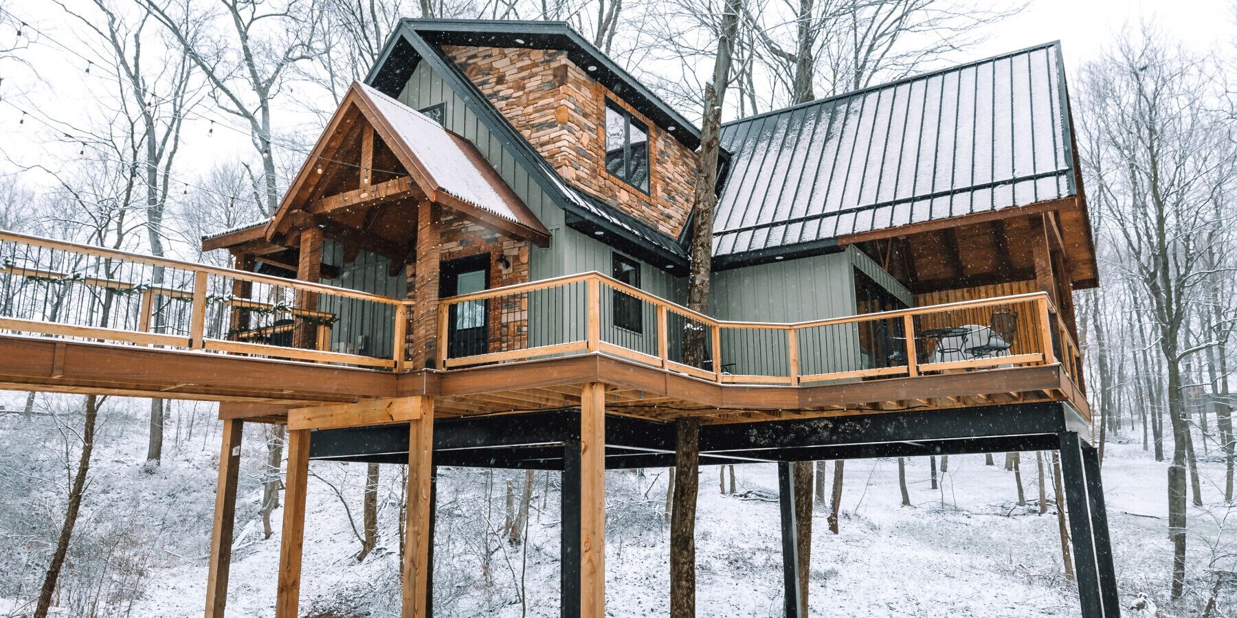 Eine mehrstöckige Holzdiele mit Balkon, gelegen in einem verschneiten Wald.