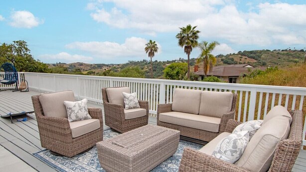 A deck with wicker furniture, including chairs and a sofa, and a patterned rug. - Fallbrook's Finest Hideaway Casa - Pool, Game Rm (Fallbrook)