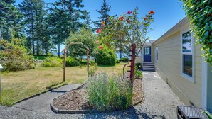 A residential property with a well-maintained garden, a wooden pergola, and a clear view of the surrounding forest. - Cozy Langley Retreat: Water Views & Beach Access (Langley)