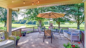 An outdoor patio with a table, chairs, and a bench.