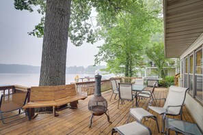 A wooden deck with outdoor furniture, a grill, and a view of a lake. - Lakefront Sister Lakes Vacation Rental w/ Dock! (Dowagiac)