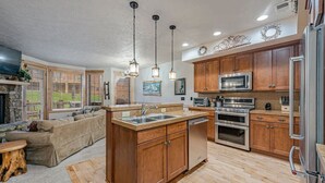 A spacious kitchen with wooden cabinets, stainless steel appliances, and a large island with a sink.