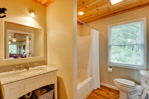A bathroom with a sink, mirror, shower, and toilet. - Spacious Georgia Escape w/ Fireplace, Deck & Grill (Lakemont)