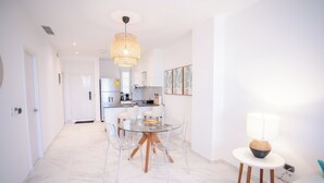 Una cocina moderna con armarios blancos, un refrigerador de acero inoxidable y un horno empotrado.