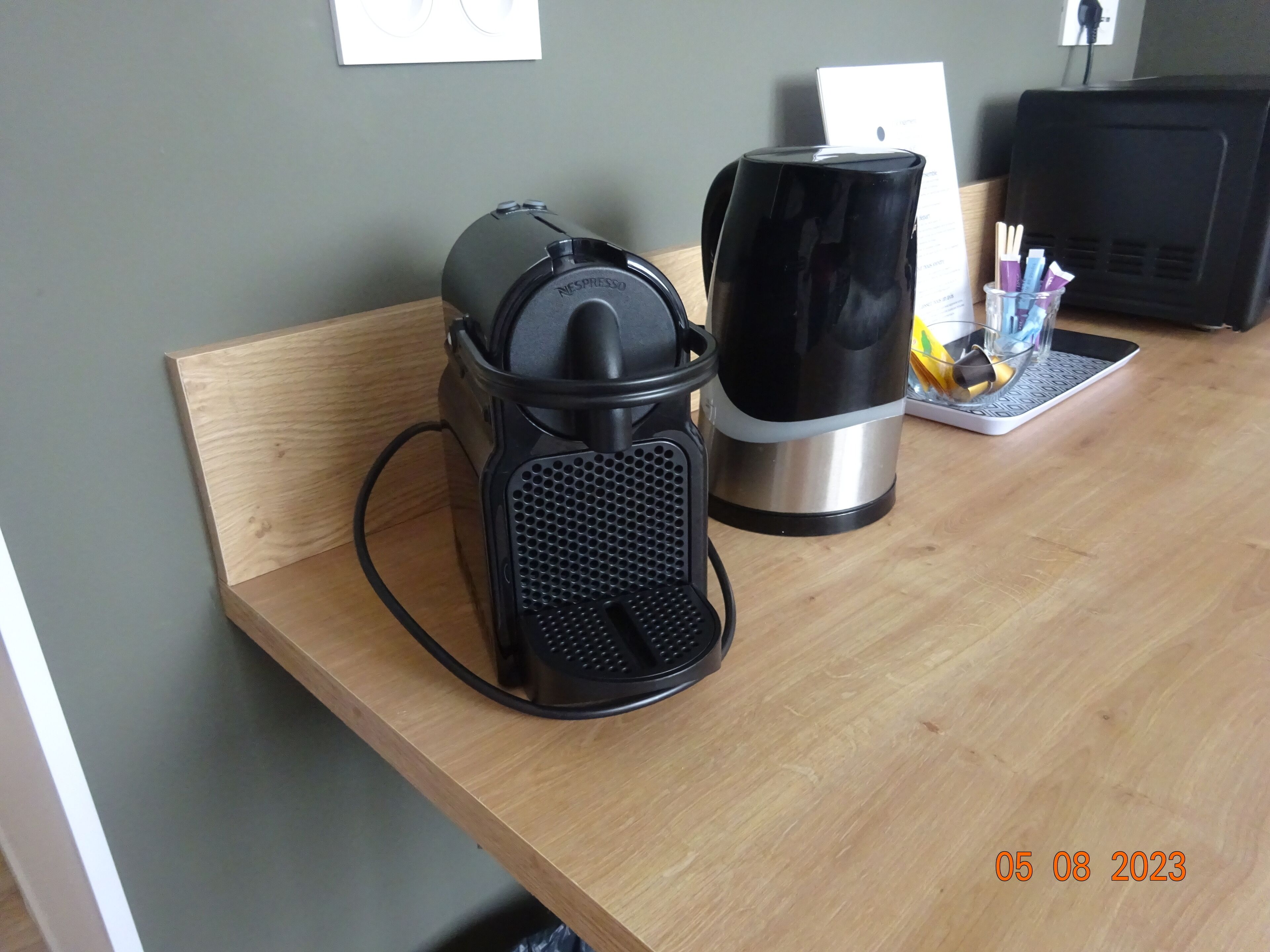 Een koffiezetapparaat en een waterkoker op een houten tafel.