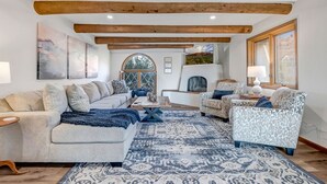 A spacious living room with a sofa set, patterned rugs, and wooden beams on the ceiling. - Hiker's Paradise infinity pool, trail access to Chapel of Holy Cross and Mystic (Sedona)